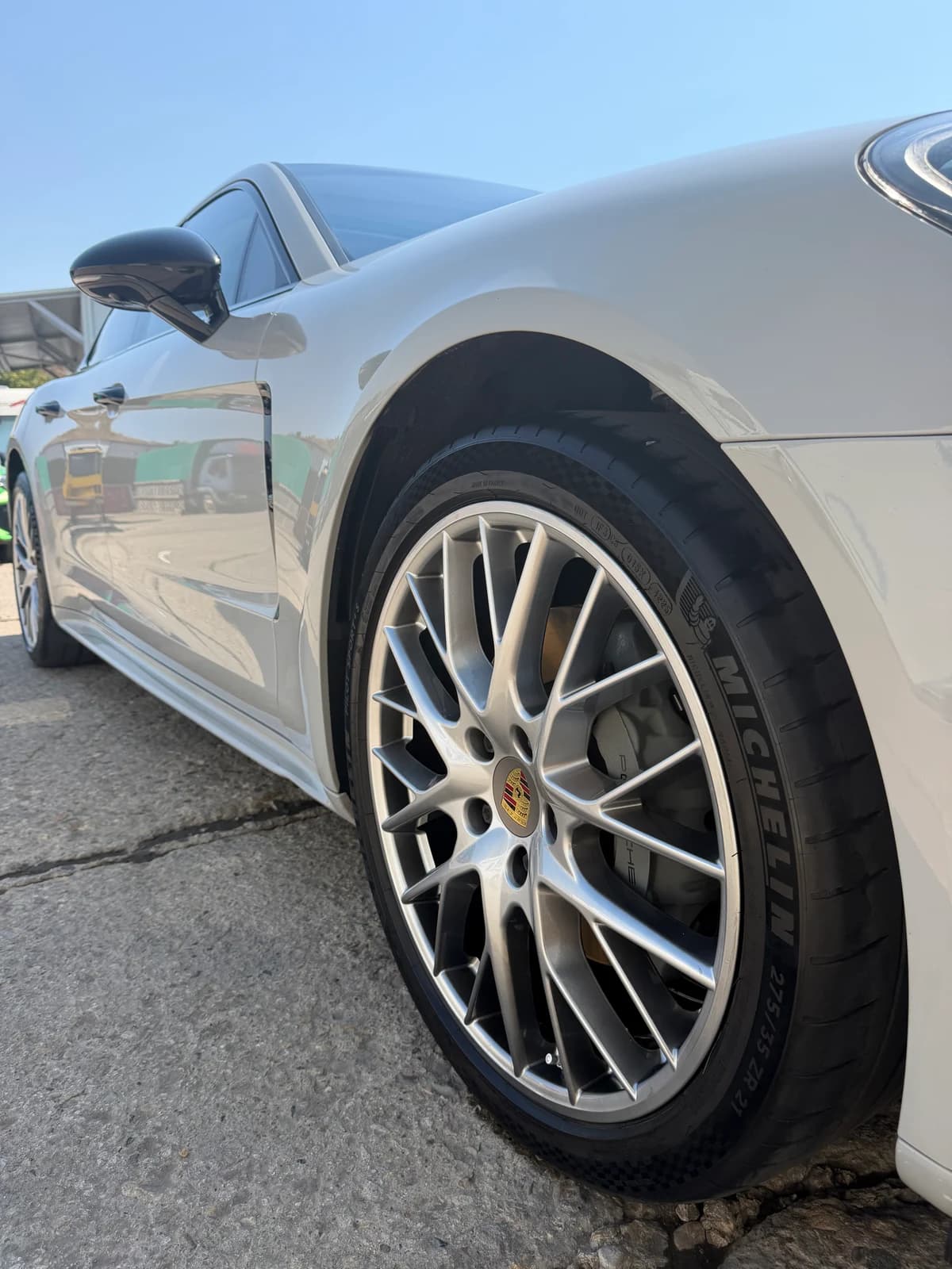 Предната джанта и страничните панели на белия Porsche Panamera